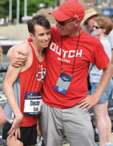Men's Track coach Joe Dunham gives a congratulatory hug to Cole Decker '16.