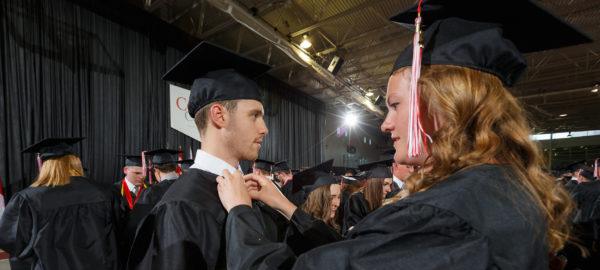 New graduates exchange alumni pins during 2017 commencement.